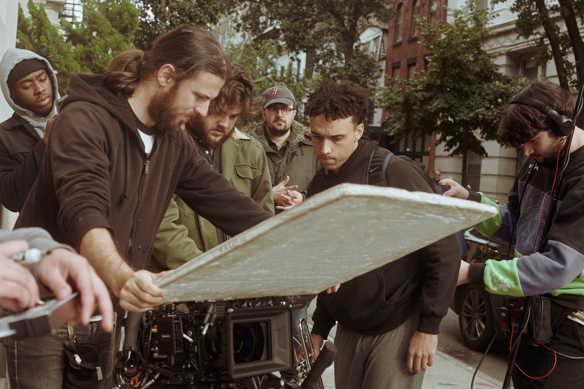 Film crew collaborating around a cinema camera on a New York City street