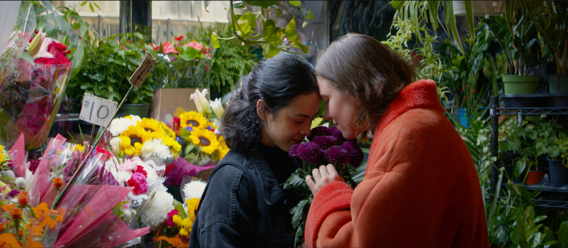 Two women sharing a quiet moment inside a colorful flower shop